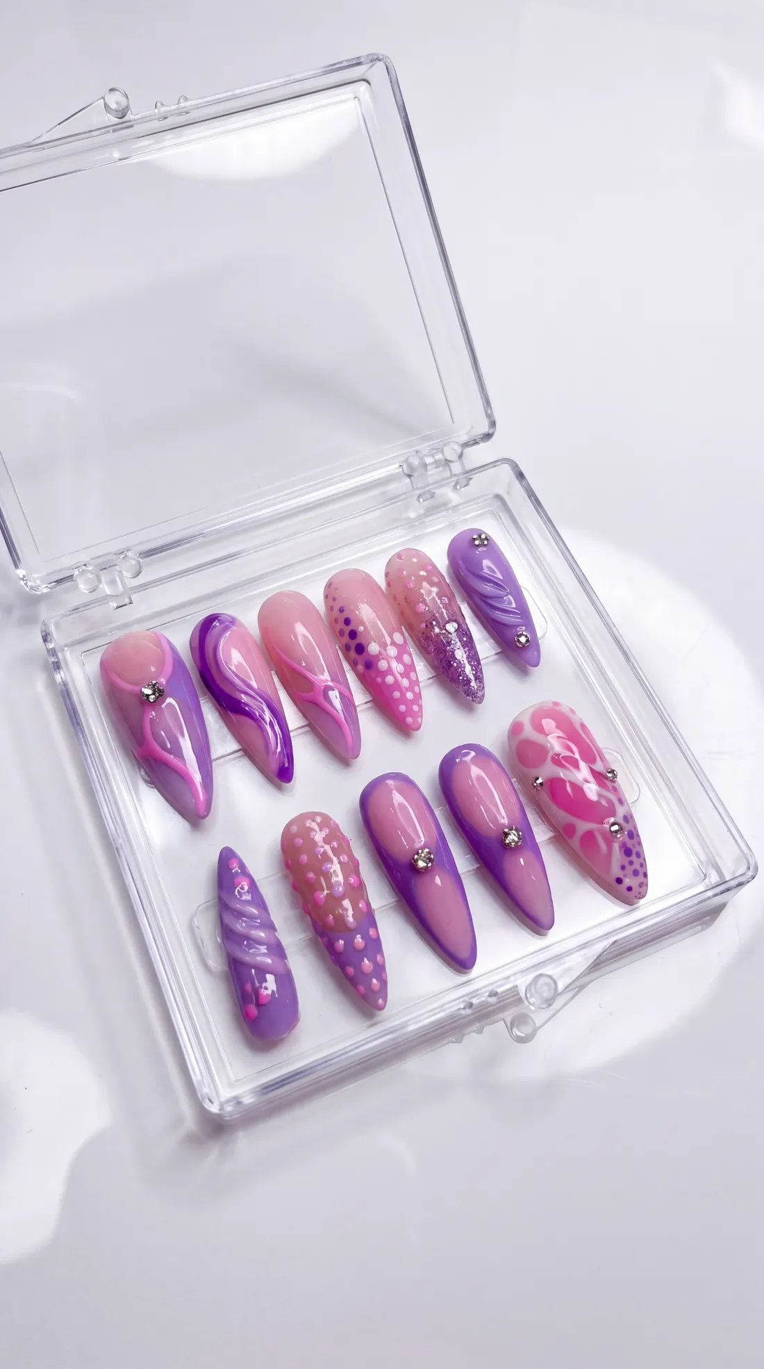 Delulu press-on nails in their case